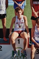 a man sitting on a bench with a medal around his neck
