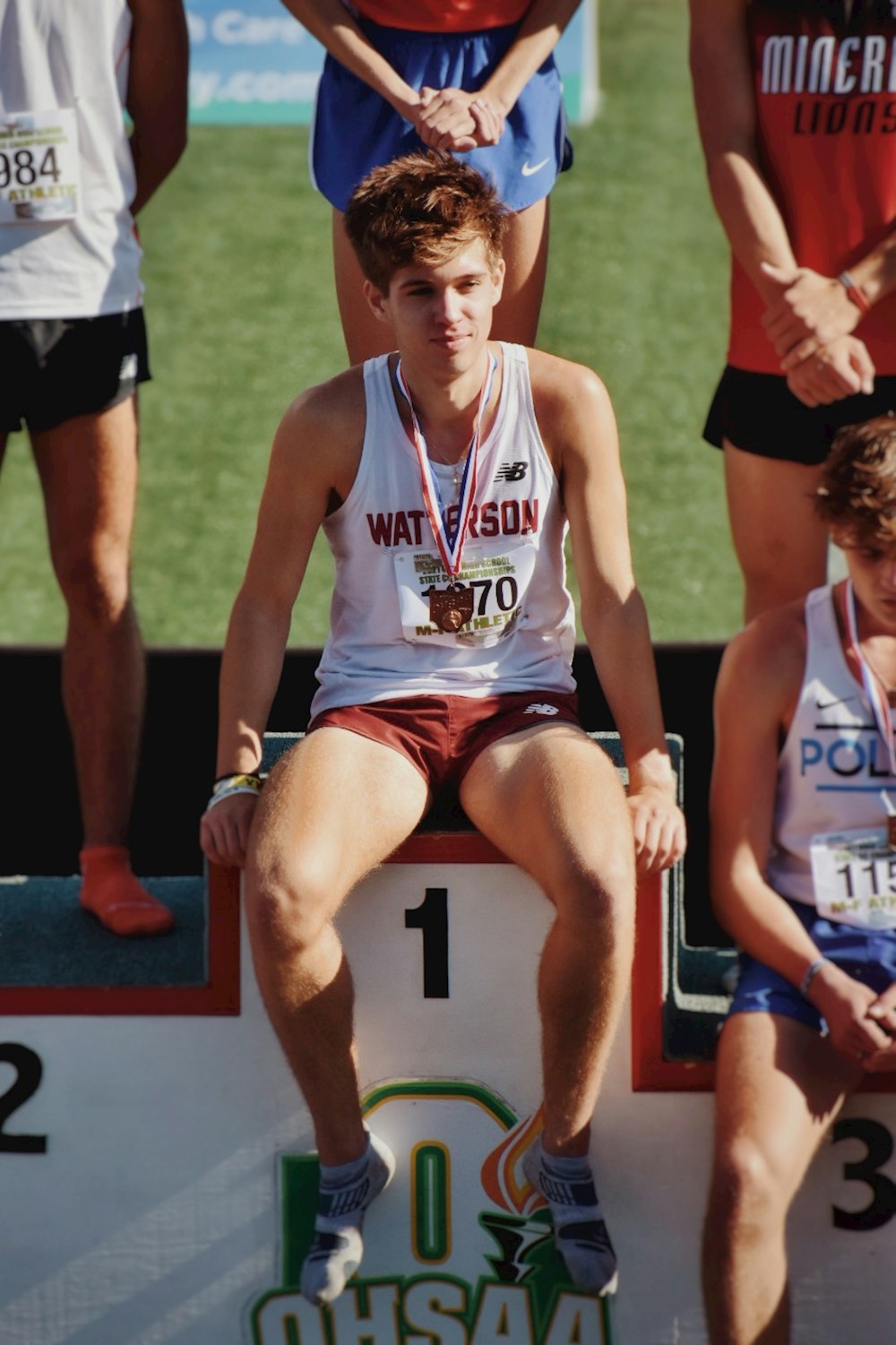 a man sitting on a bench with a medal around his neck