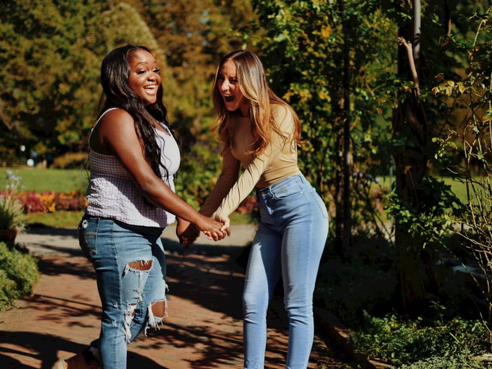 two young women are holding hands and smiling