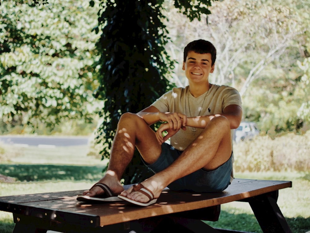 a man sitting on a picnic table in a park