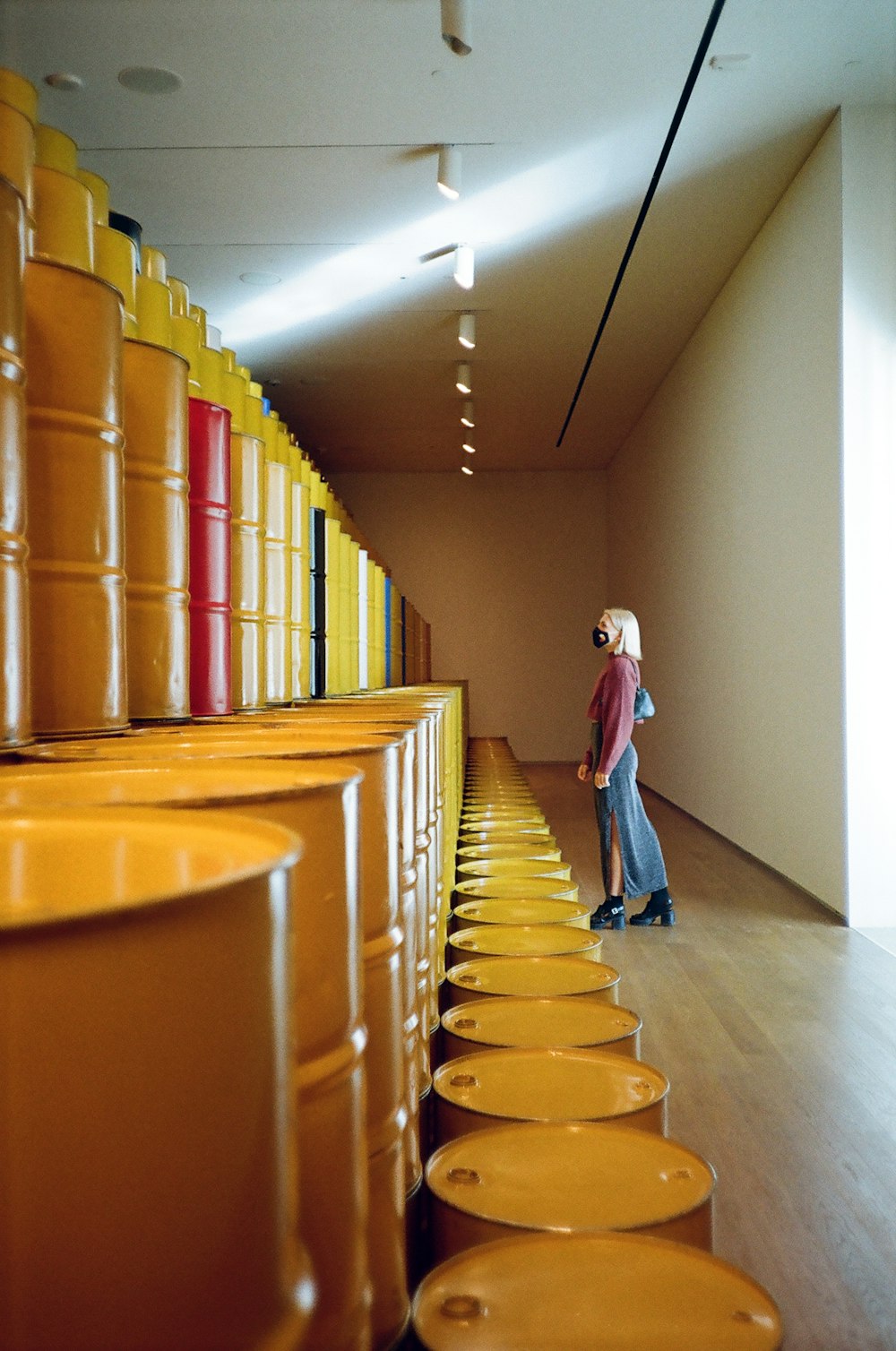 a man standing in front of a row of yellow barrels