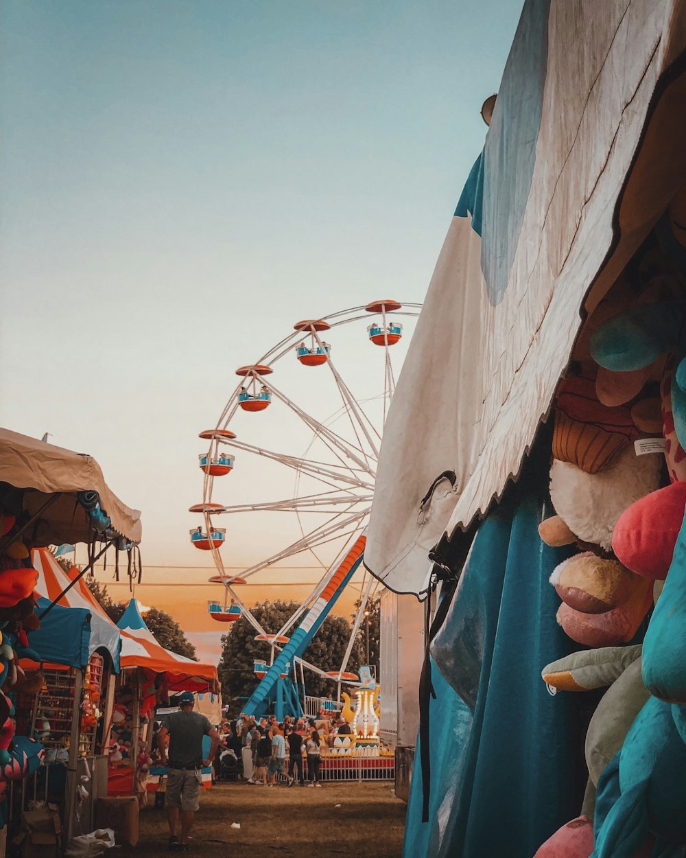 a carnival with a ferris wheel in the background