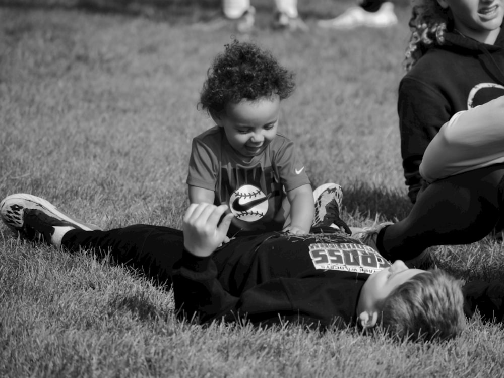 a couple of kids that are laying in the grass