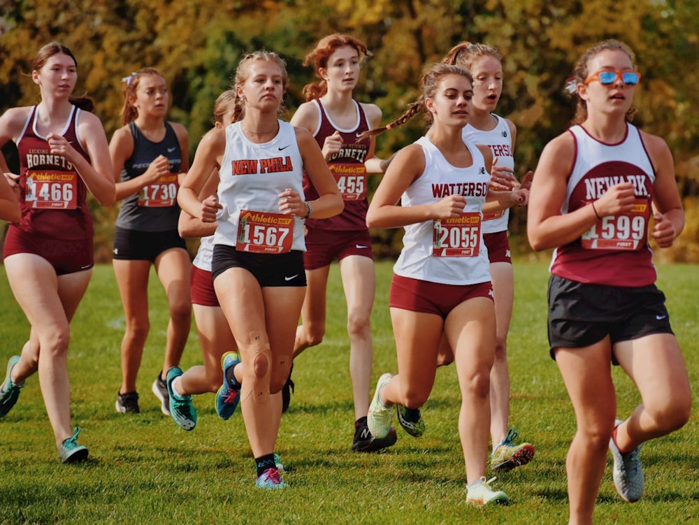 a group of girls running in a cross country race