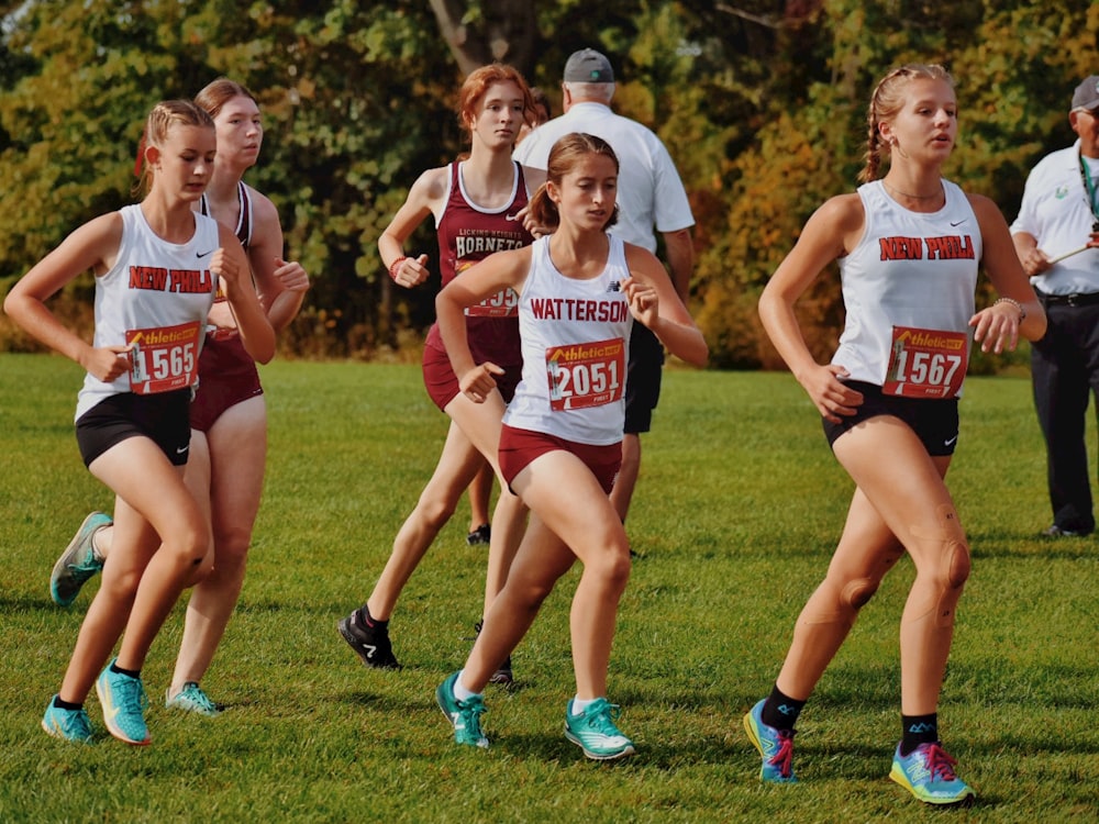 a group of girls running in a cross country race