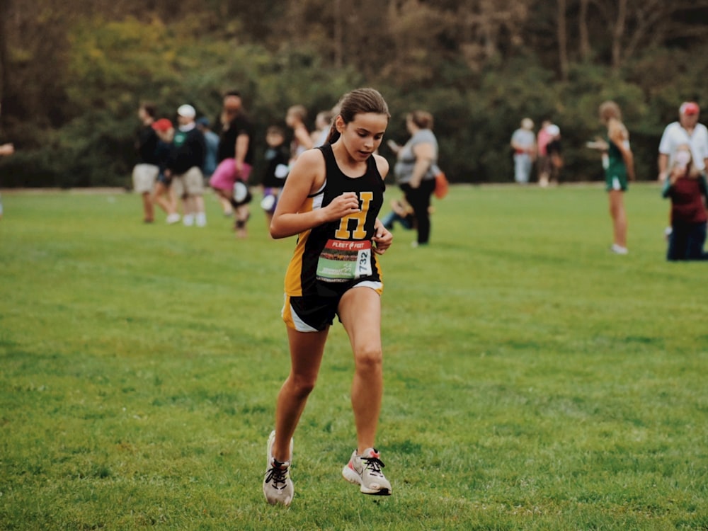 a girl running in a race in a field