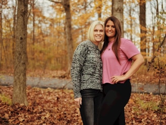 two women posing for a picture in the woods