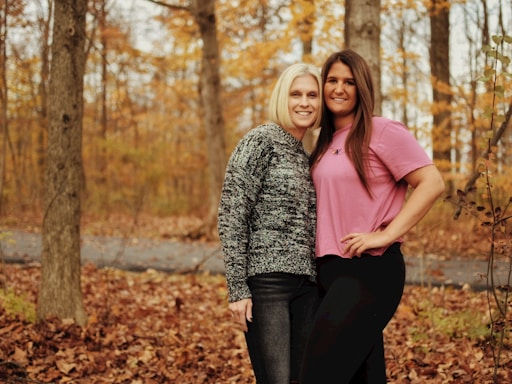 two women posing for a picture in the woods
