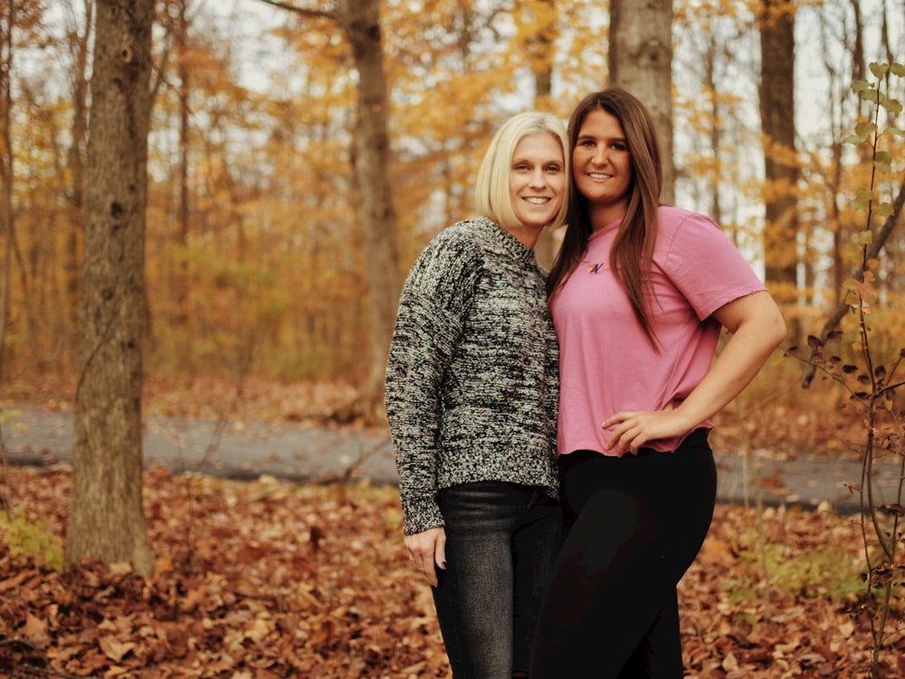 two women posing for a picture in the woods