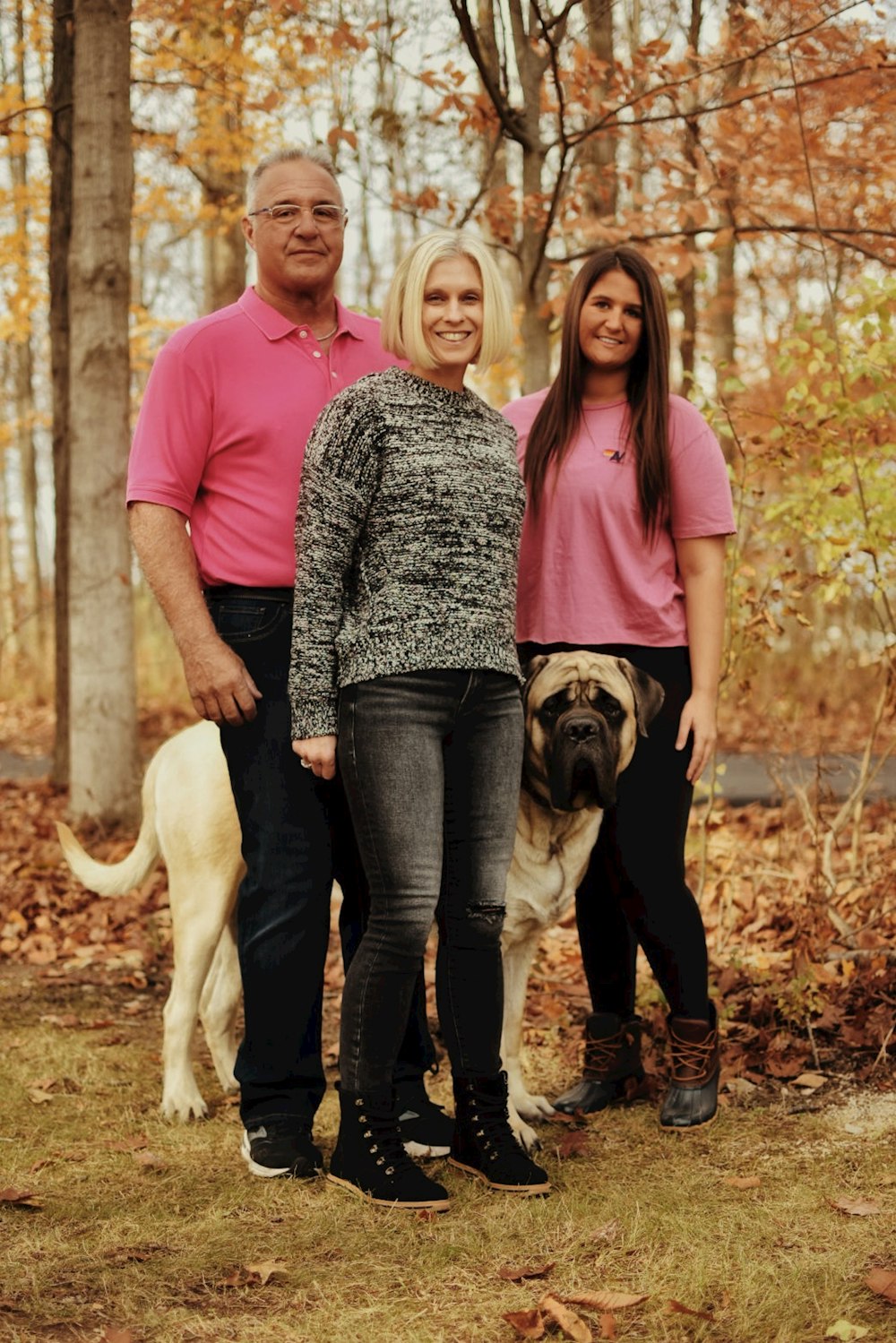 a man and two women standing next to a dog