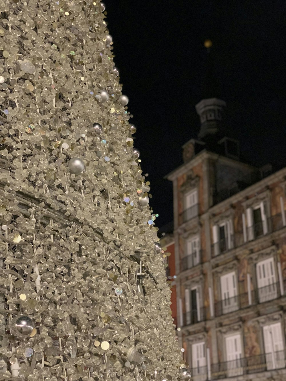 a very tall christmas tree in front of a building