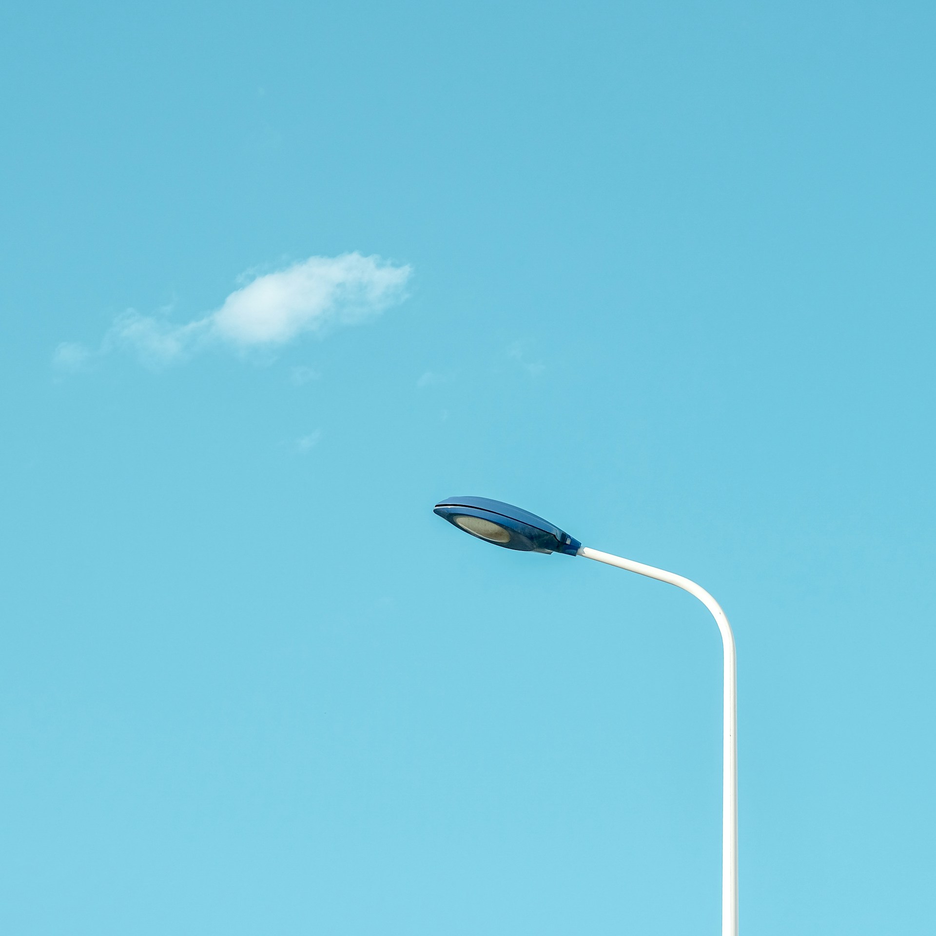 a street light with a cloud in the sky