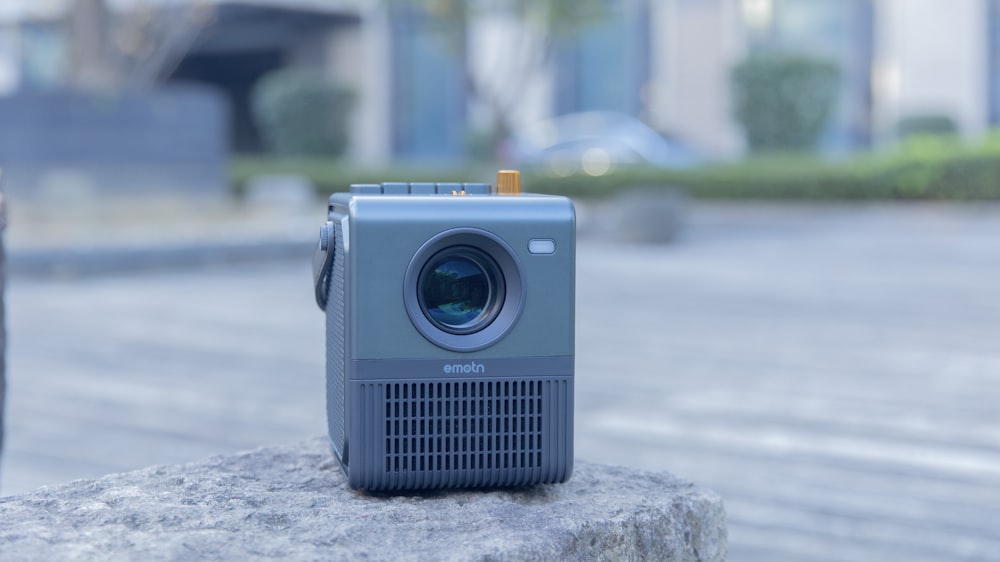 a small camera sitting on top of a rock