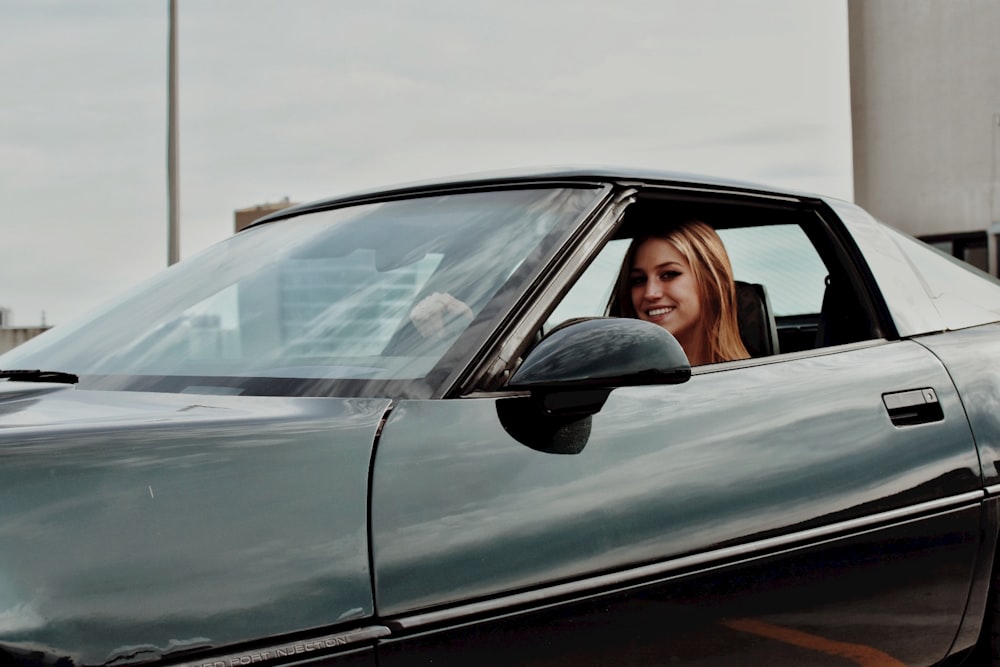 a woman sitting in the drivers seat of a car