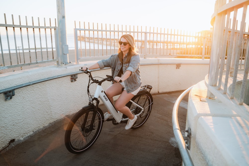 a woman riding a bike on a bridge