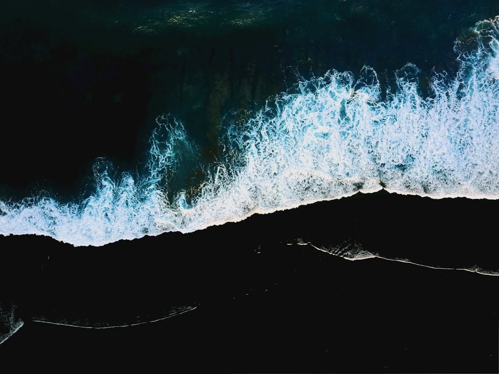 an aerial view of the ocean with waves