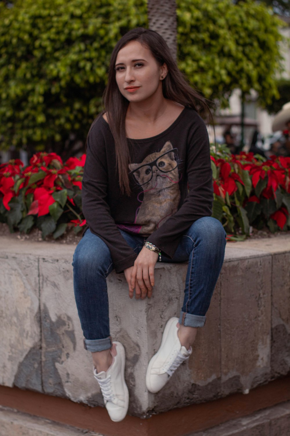 a woman sitting on top of a cement block