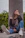 a woman sitting on a ledge with her hand on her face