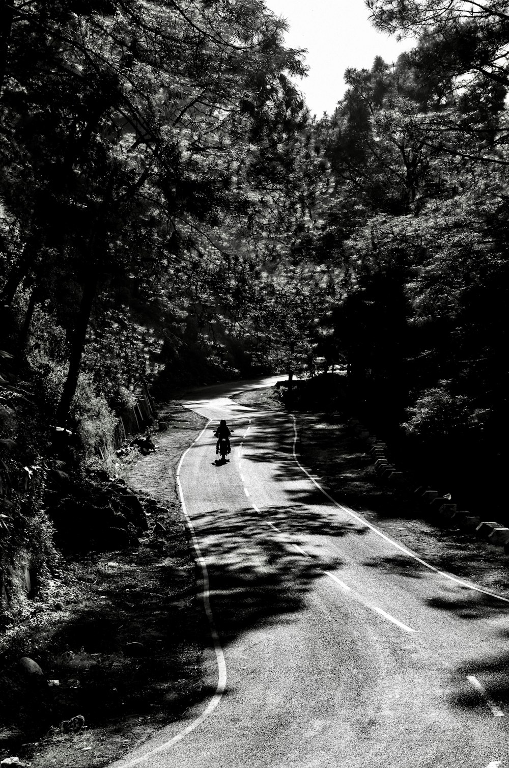 a black and white photo of a person on a motorcycle