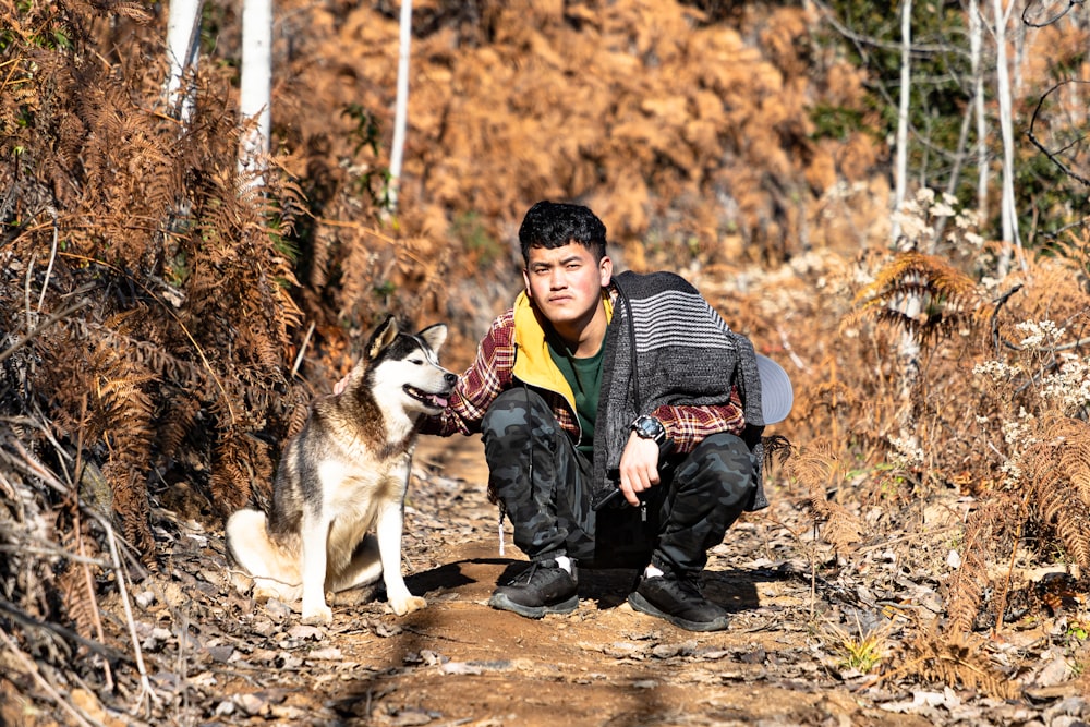 a man kneeling down next to a dog