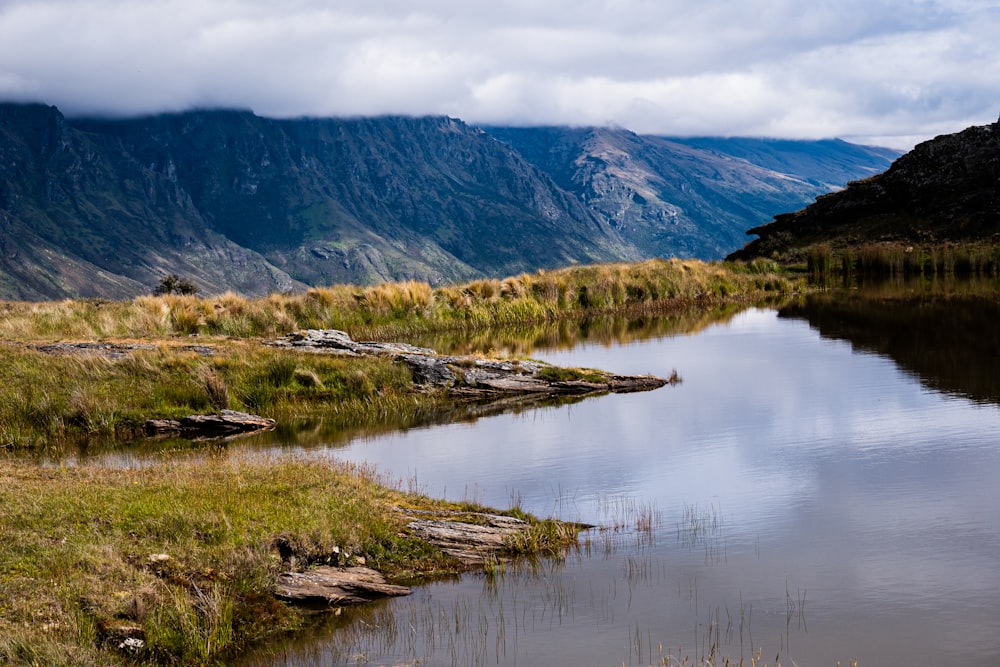 a small body of water surrounded by mountains