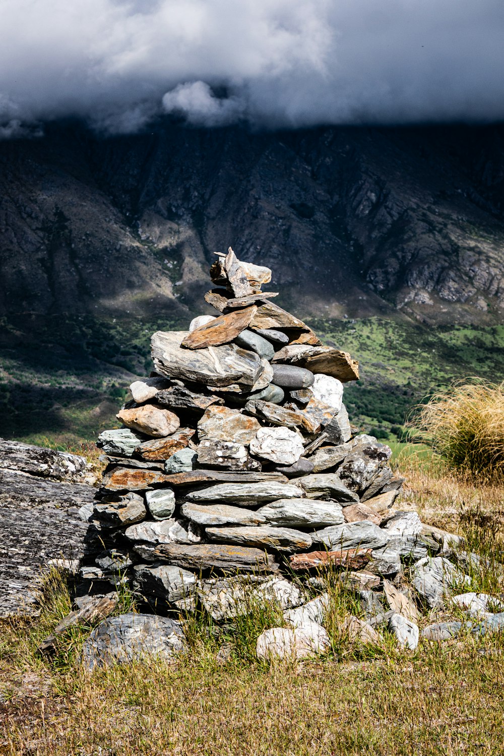 a pile of rocks sitting on top of a grass covered field