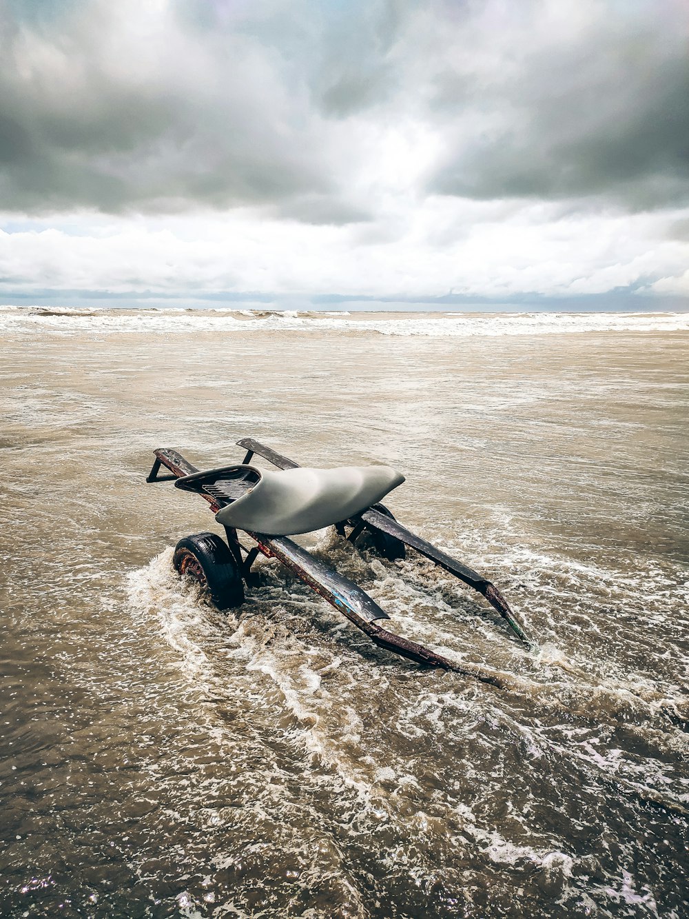 a car that is laying on its side in the water