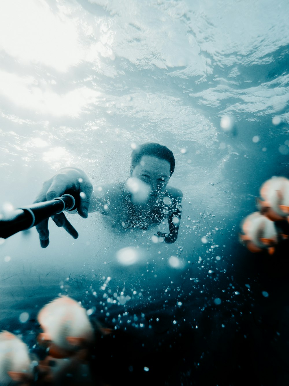 a man swimming in the ocean with lots of jellyfish