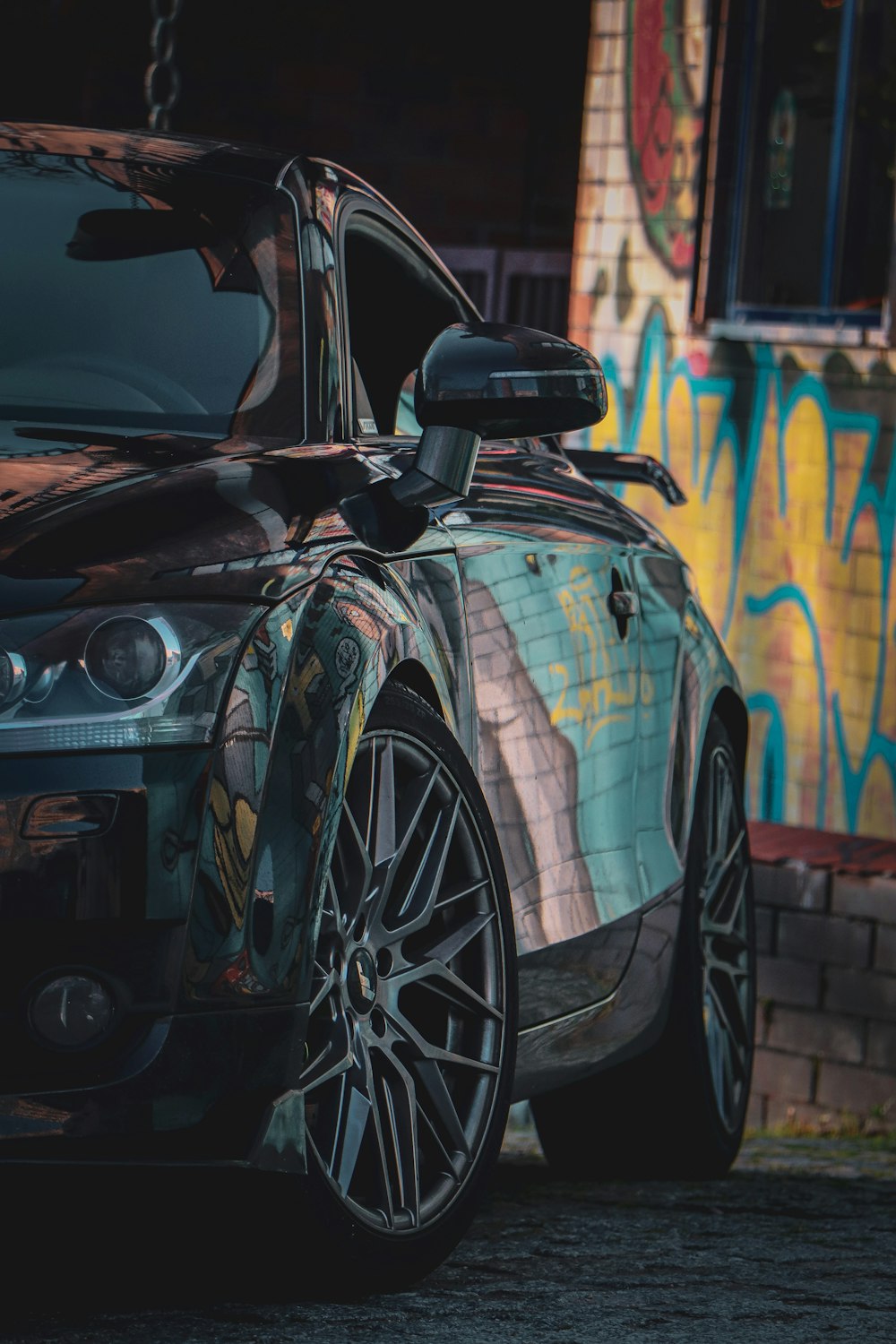 a car parked in front of a colorful wall