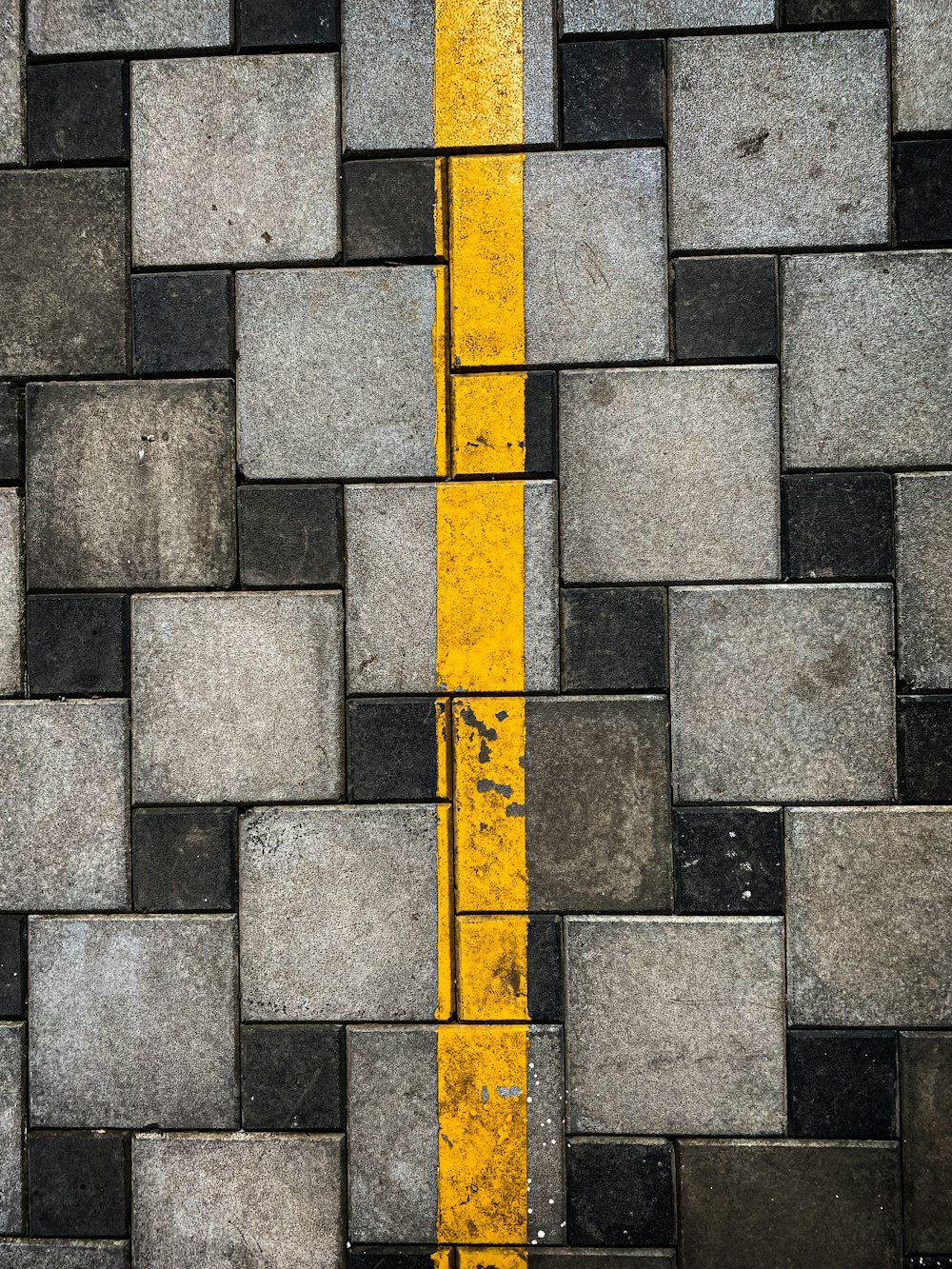 a yellow line is on the side of a brick wall