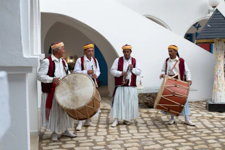 A vibrant group of local musicians playing traditional instruments in a sunlit courtyard of an ancient Kashi haveli.