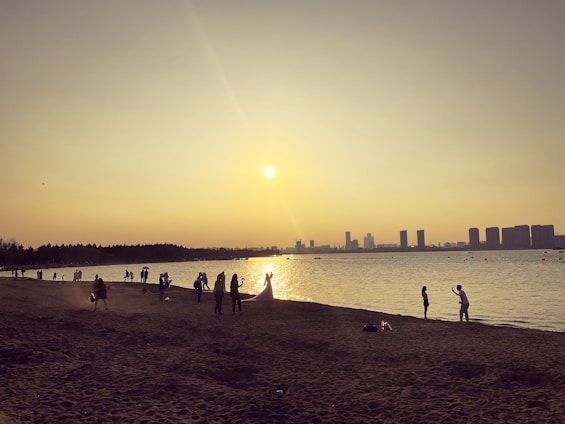 A candid shot of a videographer filming a lively beach wedding at sunset in Sharm El Sheikh.