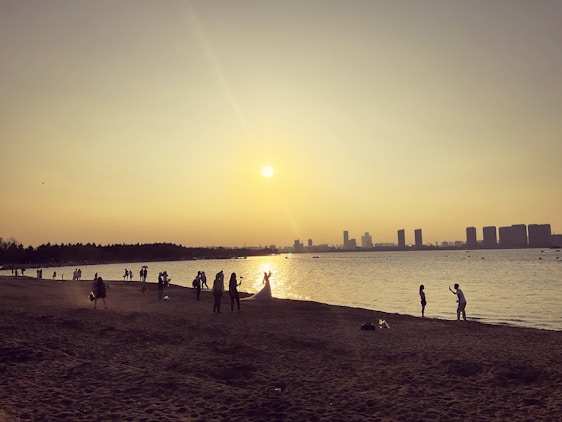 A candid shot of a videographer filming a lively beach wedding at sunset in Sharm El Sheikh.
