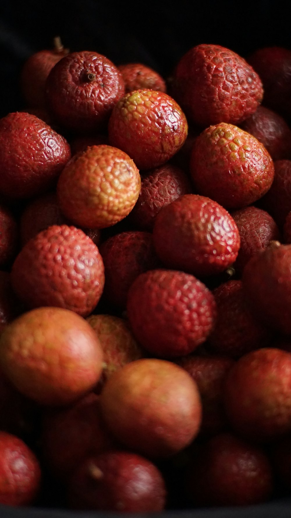a pile of red fruit sitting on top of a table
