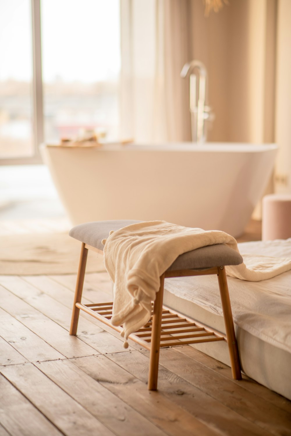 a white bath tub sitting next to a wooden floor