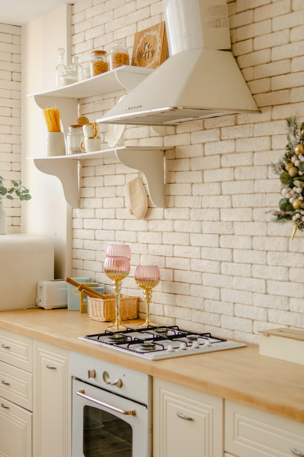 uma cozinha com um forno de fogão e uma parede de tijolos brancos