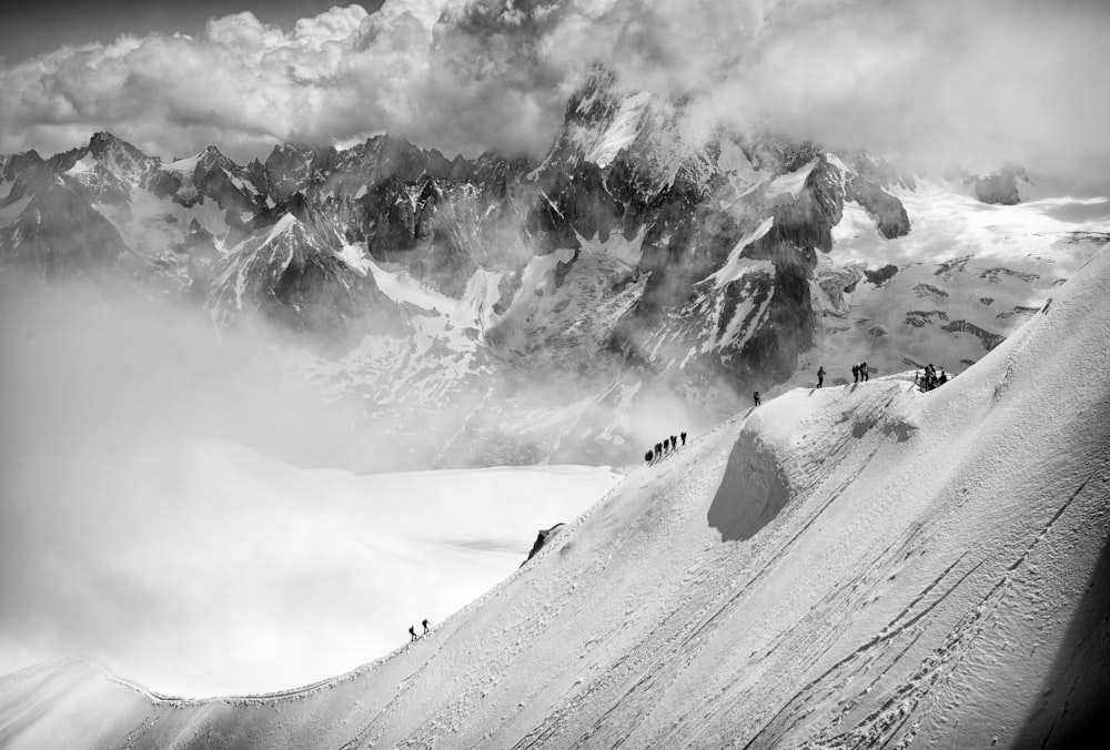 a group of people hiking up a snow covered mountain