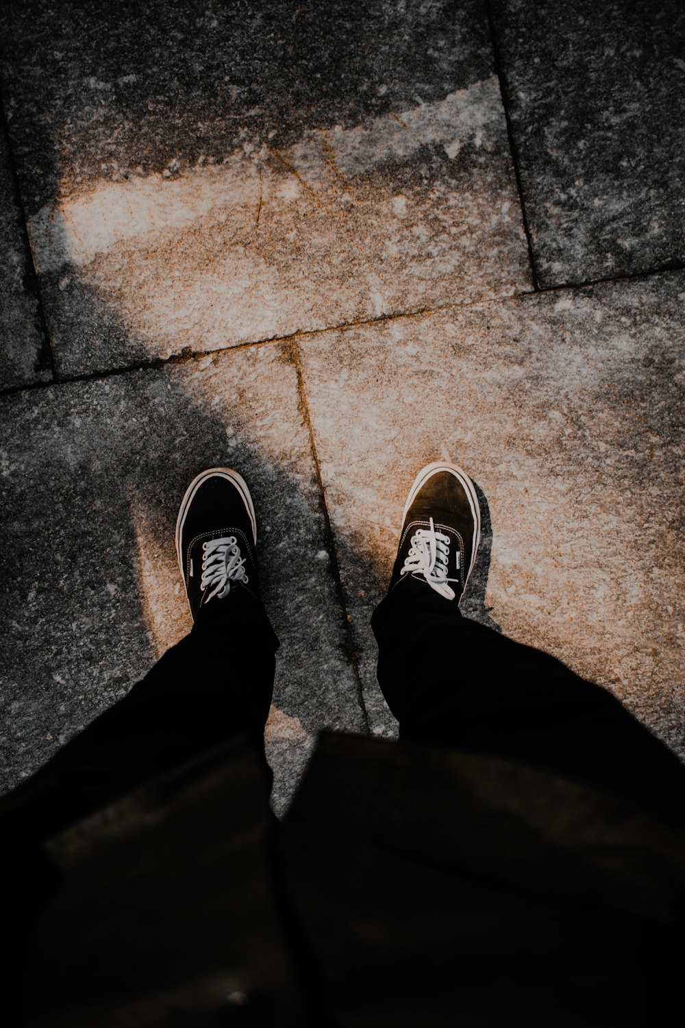 Una persona parada en una acera con los zapatos puestos