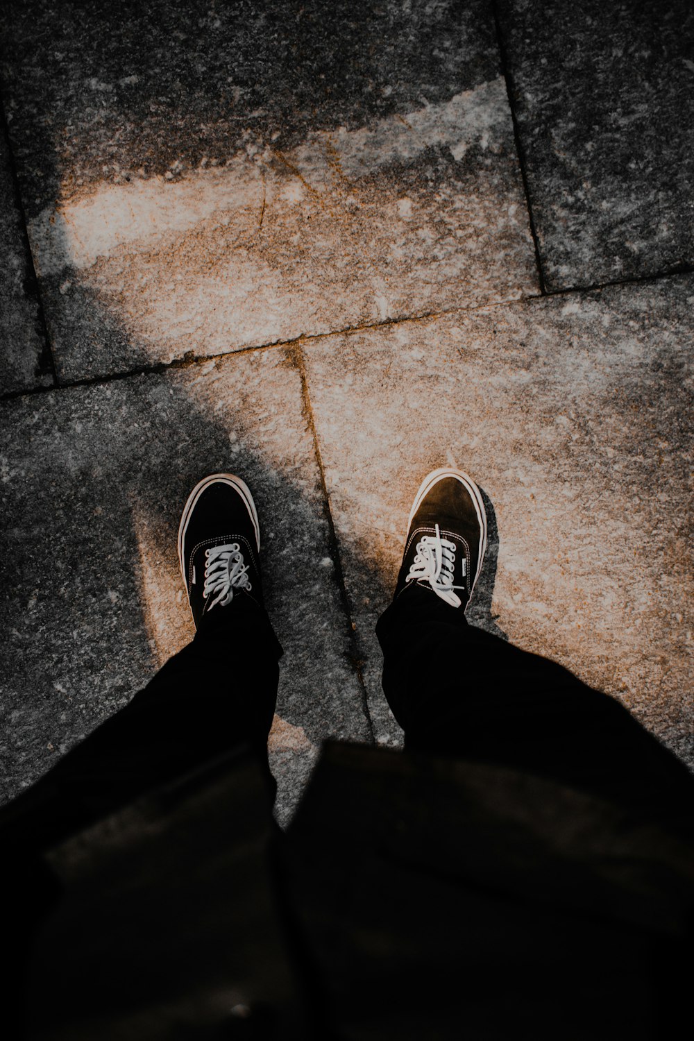 a person standing on a sidewalk with their shoes on