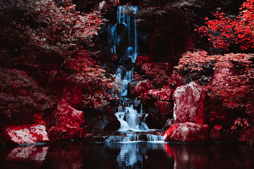 a waterfall in the middle of a lake surrounded by trees