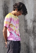 a man with a skateboard standing in front of a concrete wall