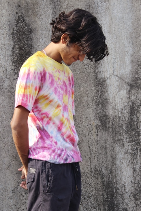 a man with a skateboard standing in front of a concrete wall