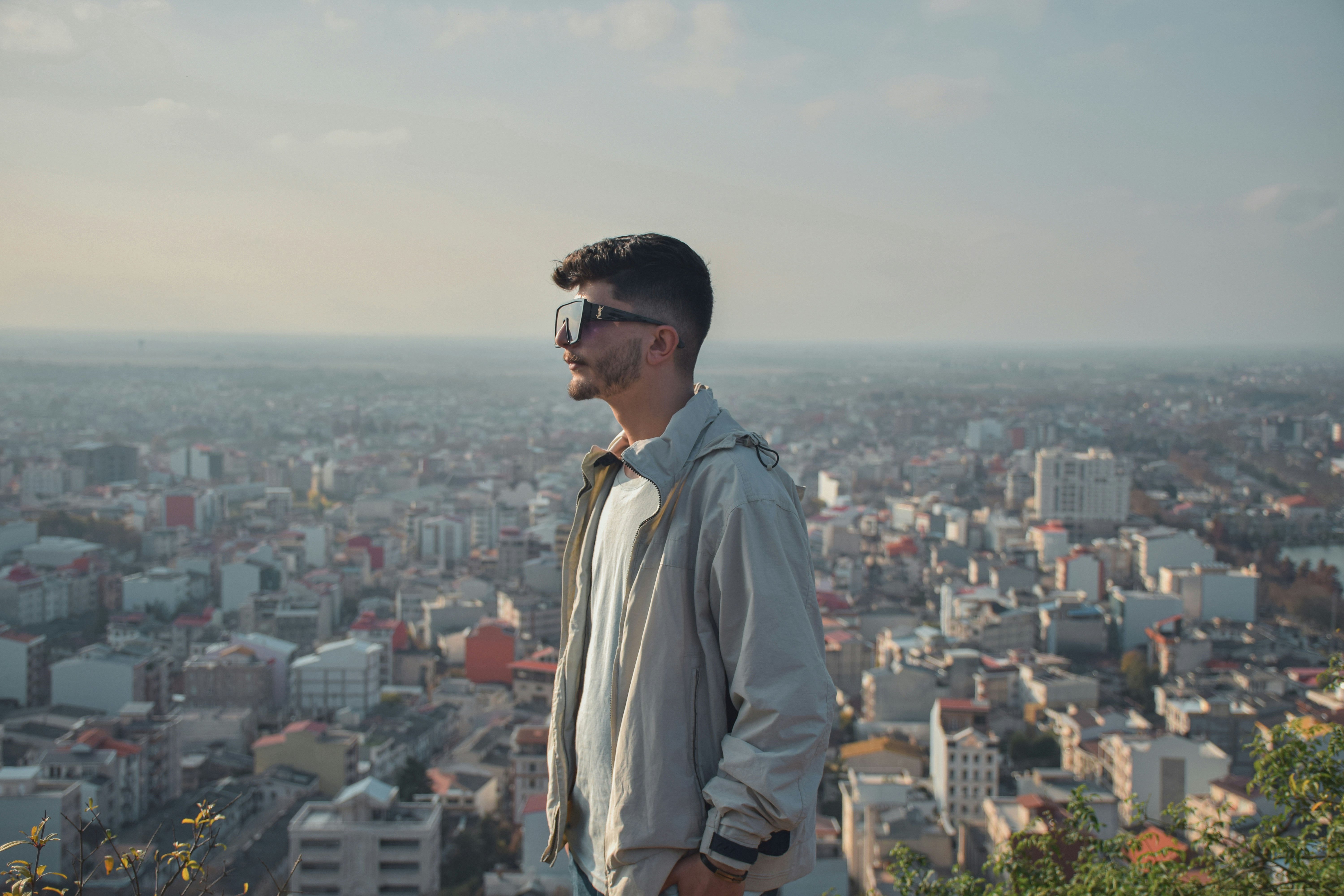 a man standing on top of a hill overlooking a city