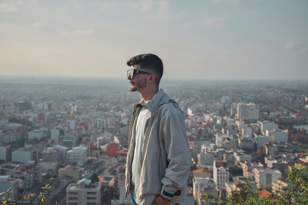 Ein Mann steht auf einem Hügel mit Blick auf eine Stadt