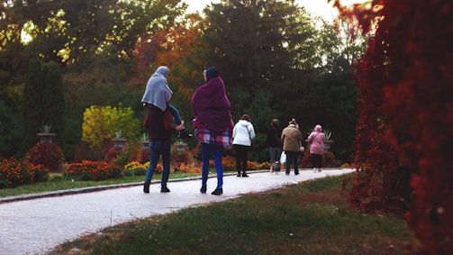 A family walking together on a leafy Rotterdam park trail during autumn.