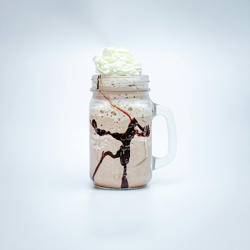 a mason jar filled with whipped cream and chocolate