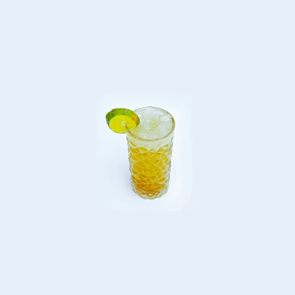 a glass of lemonade with a lime slice on the rim