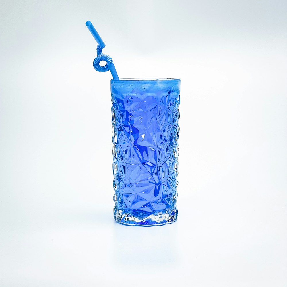 a blue glass with a toothbrush in it