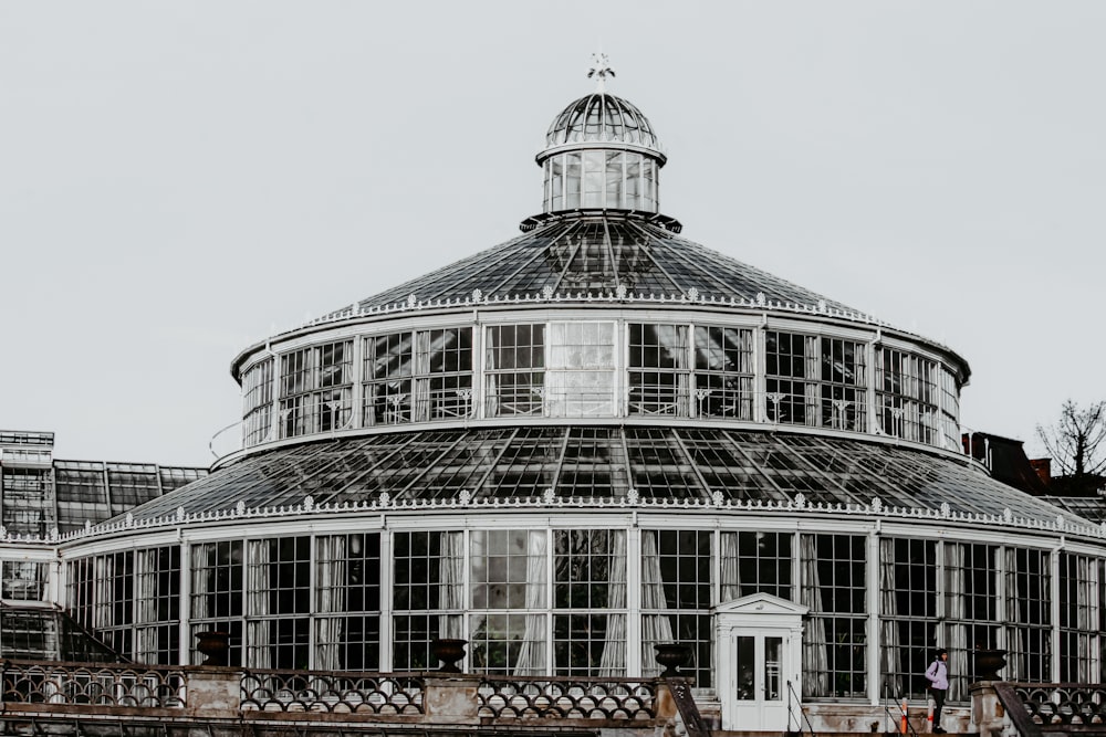 a large glass building with a clock on the top of it