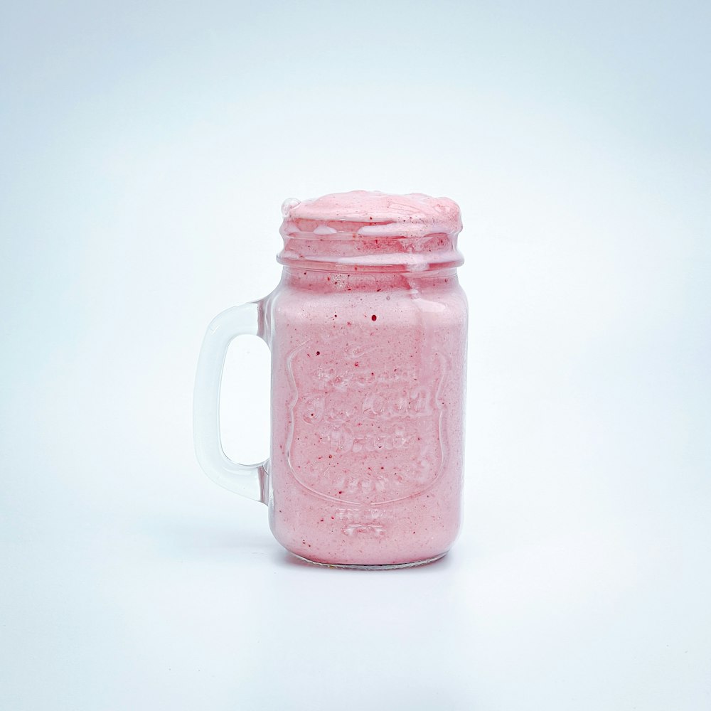 a pink drink in a mason jar on a white background